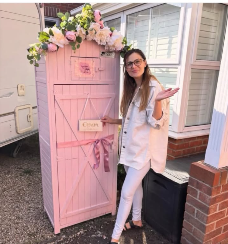 Mirela standing beside the pink Cake Shed